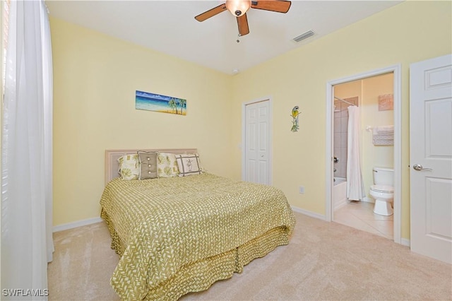 bedroom with ensuite bathroom, a closet, ceiling fan, and light colored carpet