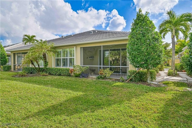 rear view of property featuring a yard