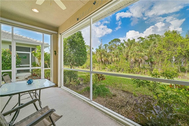 unfurnished sunroom with ceiling fan