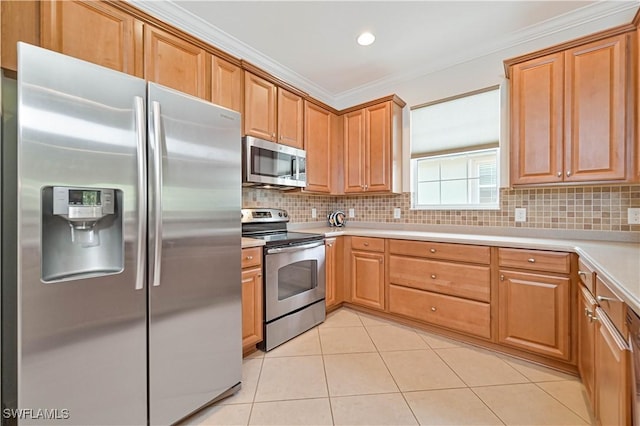 kitchen with light tile patterned floors, ornamental molding, appliances with stainless steel finishes, and tasteful backsplash