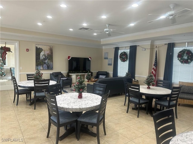 tiled dining area with ceiling fan and crown molding