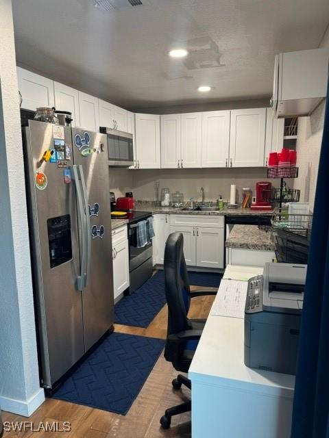 kitchen featuring dark hardwood / wood-style flooring, stainless steel appliances, white cabinetry, and sink