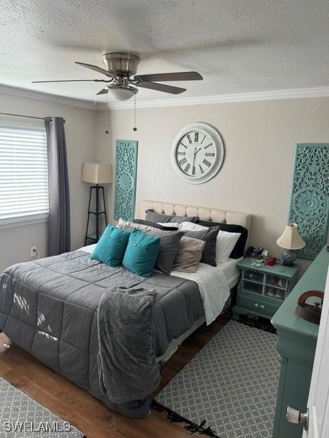 bedroom with wood-type flooring, a textured ceiling, ceiling fan, and ornamental molding