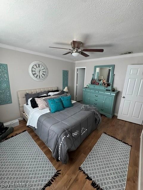 bedroom with dark hardwood / wood-style flooring, ceiling fan, crown molding, and a textured ceiling