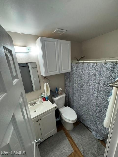 bathroom with hardwood / wood-style floors, vanity, toilet, and a shower with shower curtain