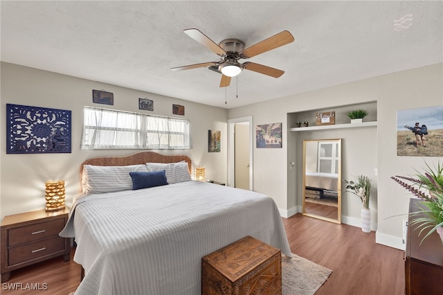 bedroom featuring ceiling fan, dark hardwood / wood-style floors, and a textured ceiling