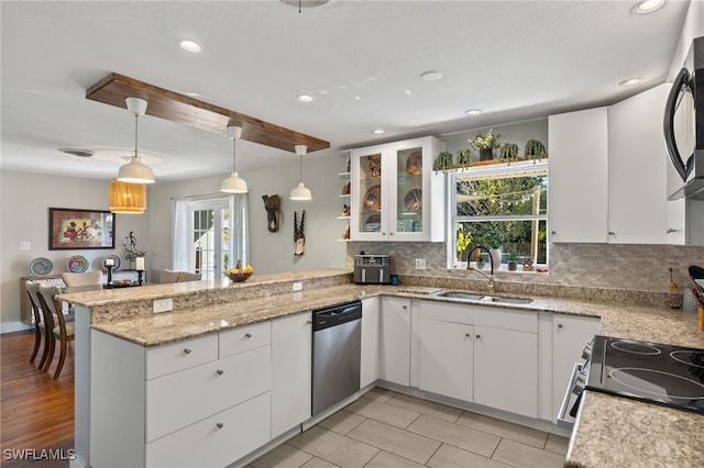 kitchen with pendant lighting, white cabinetry, stainless steel appliances, sink, and kitchen peninsula