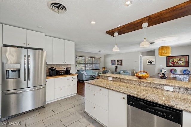 kitchen with tasteful backsplash, hanging light fixtures, white cabinets, stainless steel appliances, and light stone counters