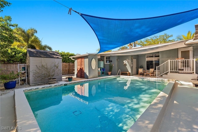 view of pool featuring a patio area and a storage shed