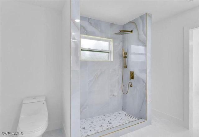 bathroom featuring a tile shower and toilet