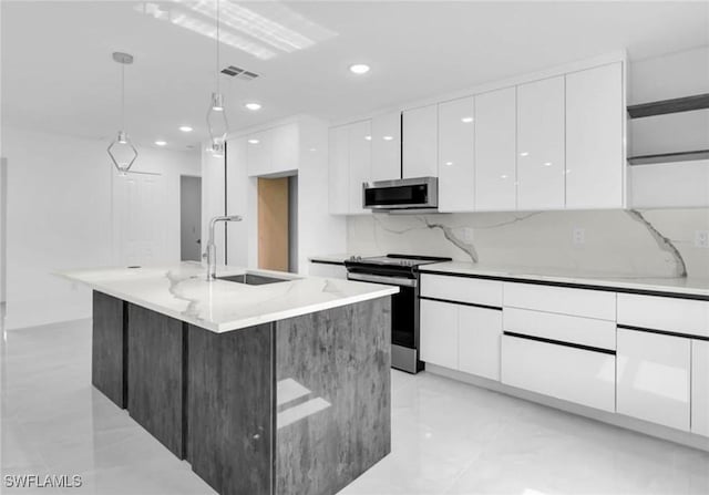 kitchen featuring white cabinetry, sink, decorative light fixtures, a kitchen island with sink, and appliances with stainless steel finishes