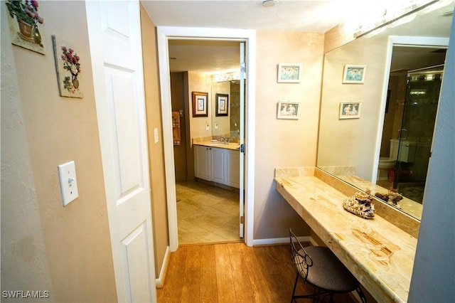 bathroom featuring hardwood / wood-style floors, vanity, toilet, and an enclosed shower