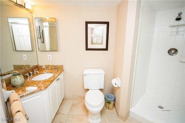 bathroom with tile patterned floors, vanity, toilet, and tiled shower