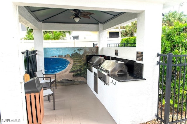 view of patio / terrace with a gazebo, a grill, ceiling fan, and exterior kitchen