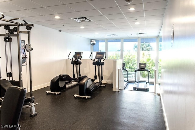 exercise room featuring a drop ceiling and expansive windows