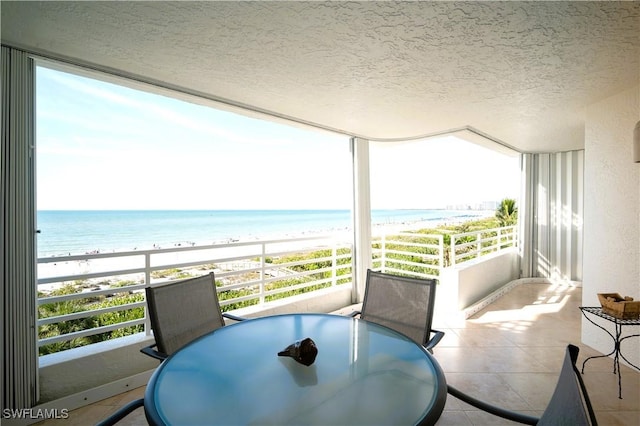 balcony featuring a water view and a beach view