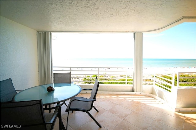 balcony featuring a water view and a beach view