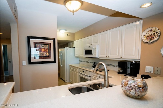 kitchen with sink, white cabinets, and white appliances