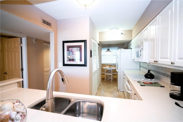 kitchen featuring backsplash, sink, white cabinets, and light tile patterned floors