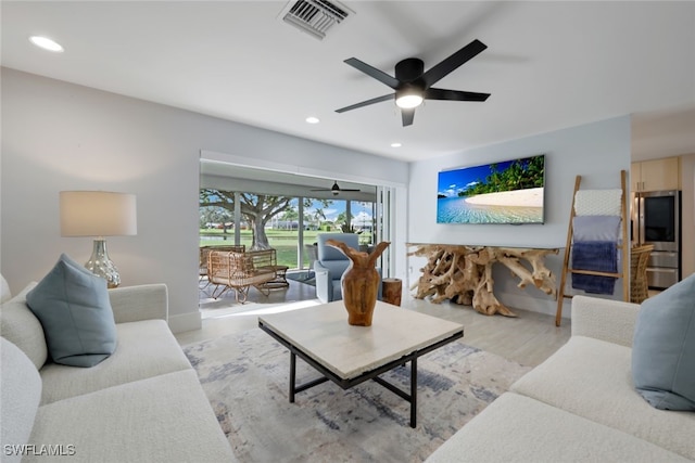 living room featuring ceiling fan and light hardwood / wood-style flooring