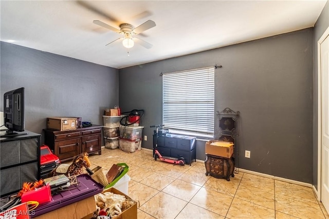 tiled bedroom featuring a ceiling fan and baseboards