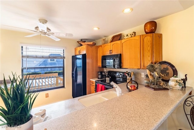 kitchen featuring a ceiling fan, light stone counters, black appliances, a sink, and recessed lighting