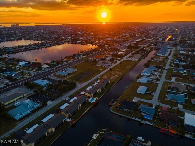 aerial view at dusk featuring a water view