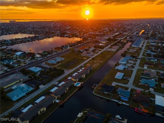 aerial view at dusk featuring a water view