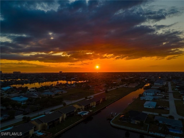 aerial view at dusk featuring a water view