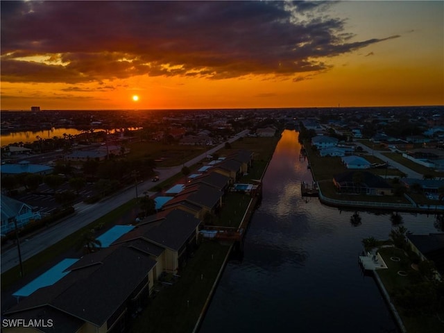 aerial view at dusk featuring a water view