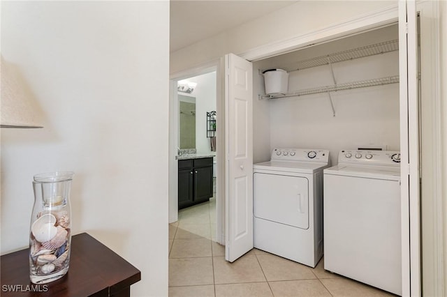 clothes washing area featuring light tile patterned floors and washer and clothes dryer