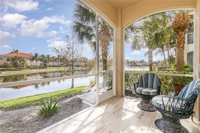 sunroom / solarium featuring a water view