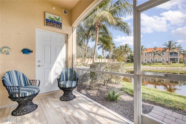 sunroom / solarium featuring a water view