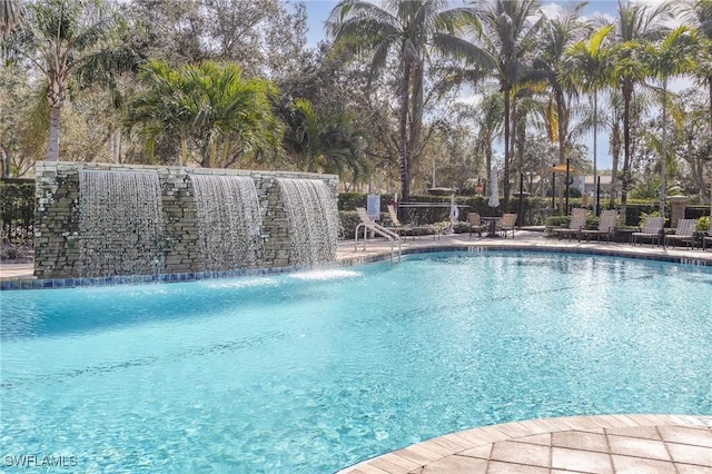 view of swimming pool with pool water feature