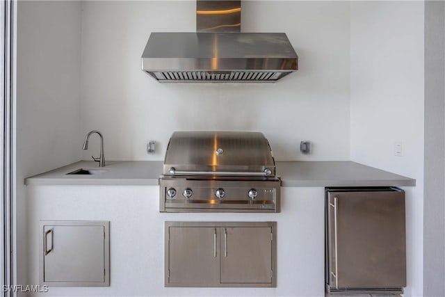 kitchen with sink, wall chimney exhaust hood, and fridge