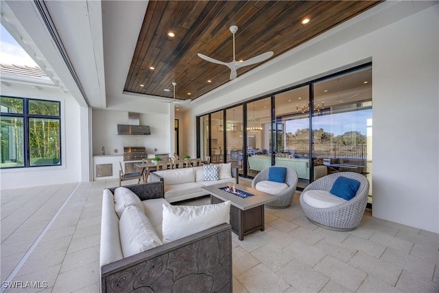 view of patio featuring ceiling fan, area for grilling, grilling area, and an outdoor living space with a fire pit