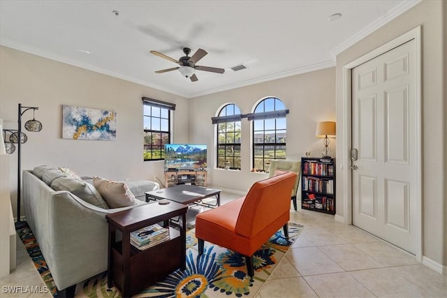 tiled living room featuring a fireplace, ceiling fan, and crown molding