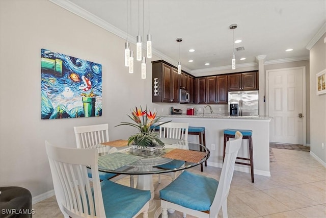 tiled dining space featuring crown molding and sink