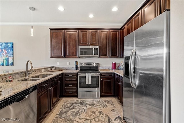 kitchen featuring sink, light stone counters, pendant lighting, dark brown cabinets, and appliances with stainless steel finishes