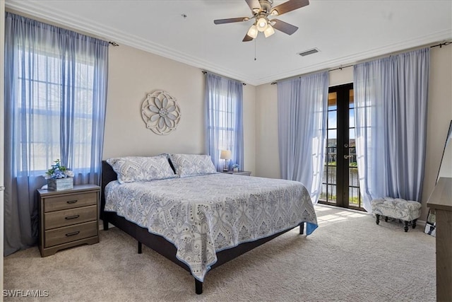 carpeted bedroom featuring multiple windows, ceiling fan, and french doors