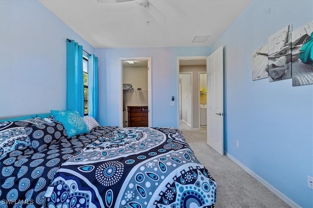 bedroom with a closet, light colored carpet, a spacious closet, and ceiling fan