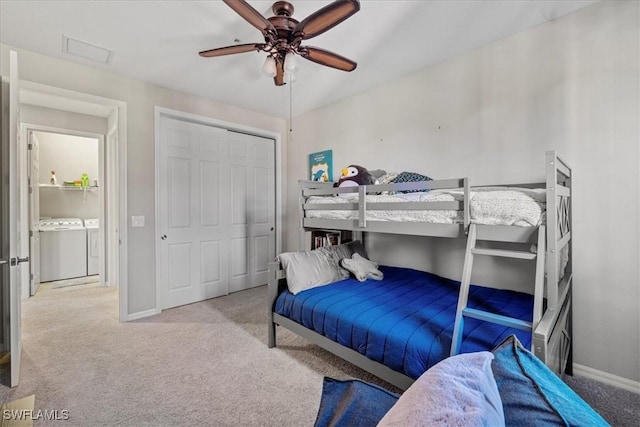 carpeted bedroom with a closet, washer and clothes dryer, and ceiling fan