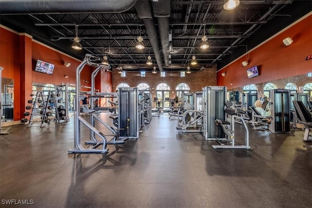 gym featuring a towering ceiling and track lighting