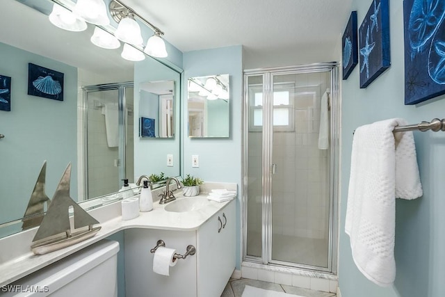 bathroom featuring toilet, a shower stall, and vanity