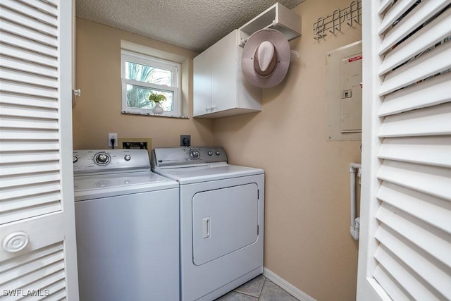 laundry room with washing machine and clothes dryer, cabinet space, a textured ceiling, electric panel, and baseboards