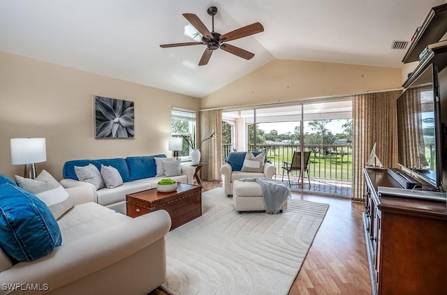 living area with lofted ceiling, ceiling fan, and light wood-style floors