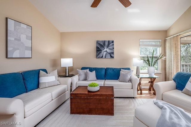 living room featuring a ceiling fan and lofted ceiling