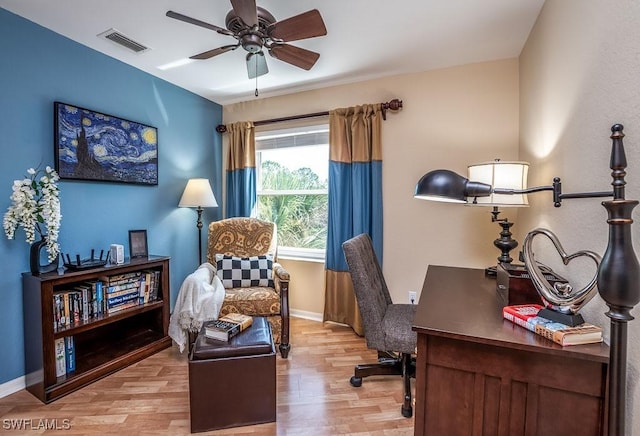 office space featuring light wood finished floors, baseboards, and visible vents