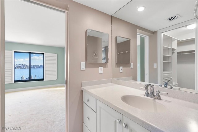 bathroom featuring vanity, visible vents, and baseboards