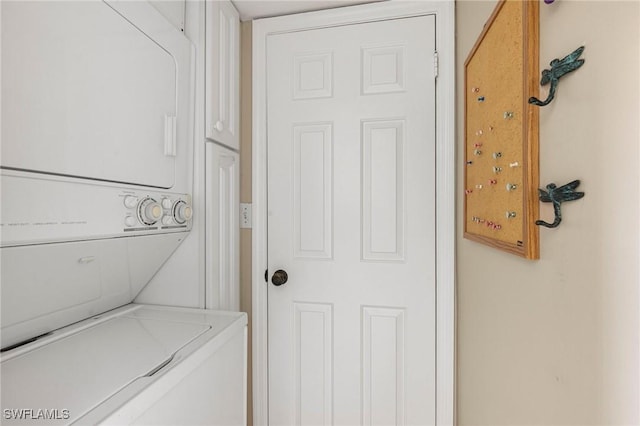 clothes washing area featuring stacked washing maching and dryer and laundry area